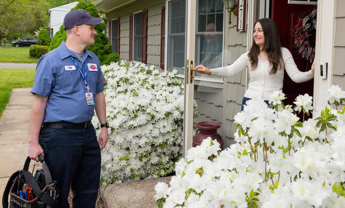 A Meyer and Depew technician greeting a client at the front door of her home.