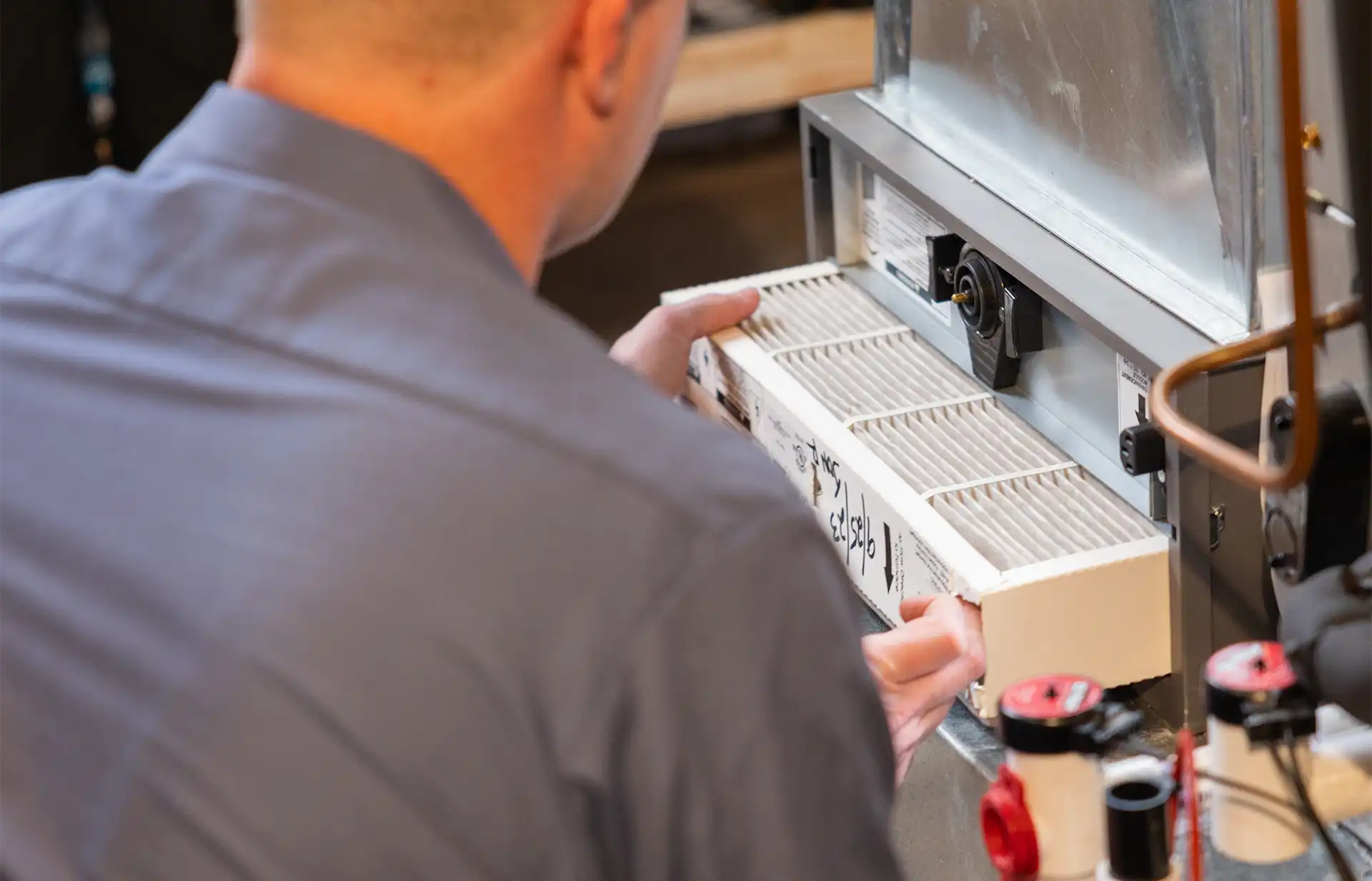 A technician replacing the filter in a furnace in Chatham, NJ.